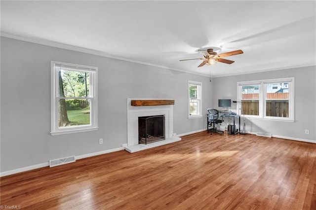 2703 W Cornwallis Dr, Greensboro, NC 27408 - unfurnished living room featuring ornamental molding, a brick fireplace, visible vents, and wood finished floors