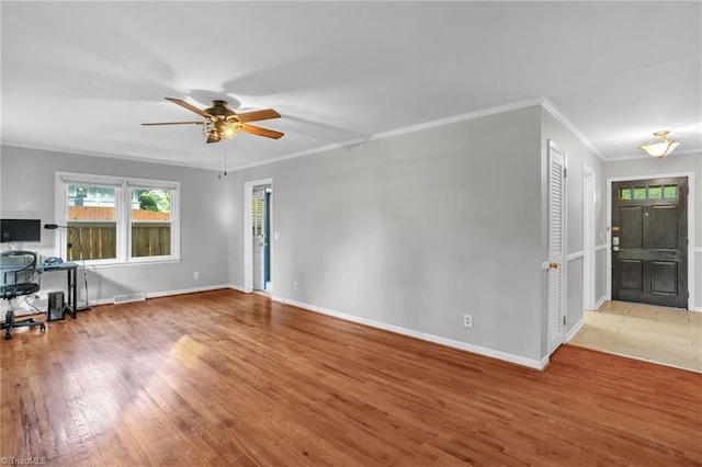2703 W Cornwallis Dr, Greensboro, NC 27408 - unfurnished living room featuring baseboards, ornamental molding, ceiling fan, and wood finished floors