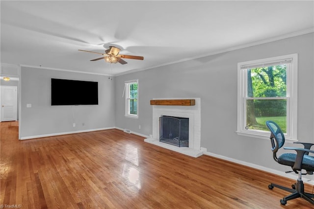 2703 W Cornwallis Dr, Greensboro, NC 27408 - unfurnished living room with wood finished floors, a brick fireplace, baseboards, ceiling fan, and ornamental molding