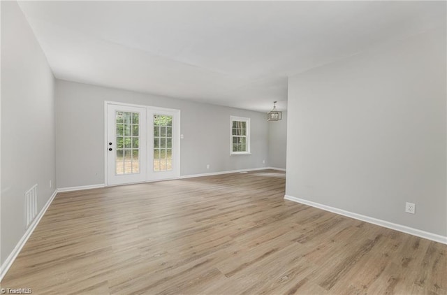 2725 New Walkertown Rd, Winston-Salem, NC 27105 - unfurnished room featuring light wood-type flooring, baseboards, and a chandelier