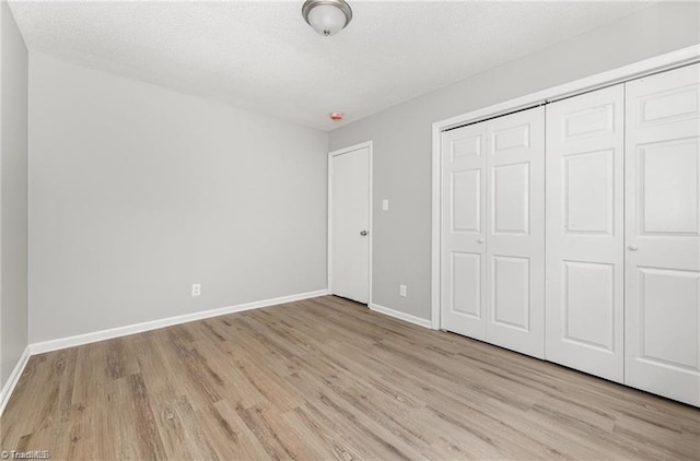 unfurnished bedroom featuring light wood-type flooring and a closet