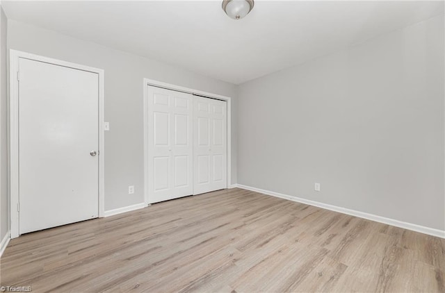 unfurnished bedroom featuring light wood-type flooring and a closet