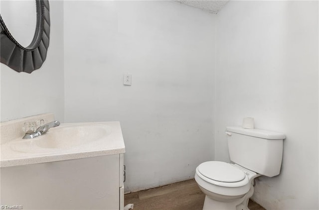 bathroom with vanity, wood-type flooring, and toilet