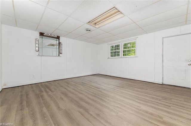 basement with light hardwood / wood-style flooring and a drop ceiling