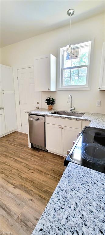 kitchen with dishwasher, a sink, white cabinetry, light wood-style floors, and electric stove
