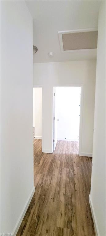 hallway featuring wood finished floors and baseboards
