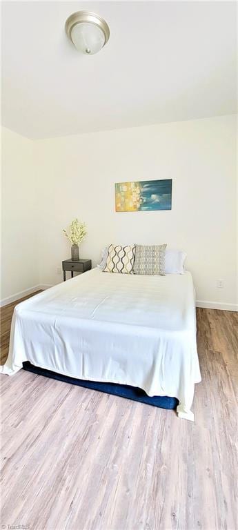bedroom with wood finished floors and baseboards