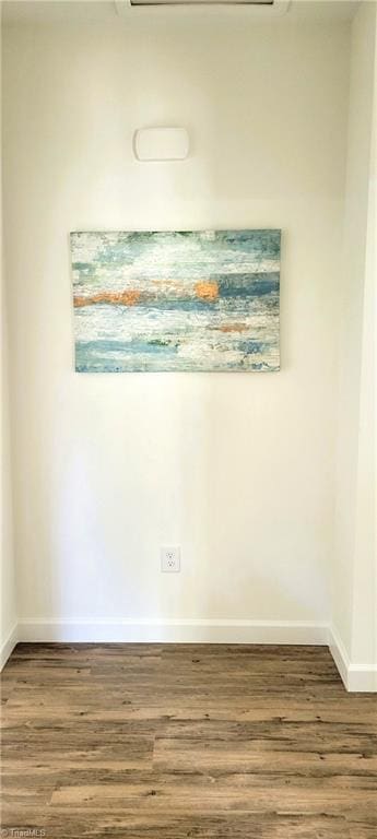 empty room featuring dark wood-type flooring and baseboards