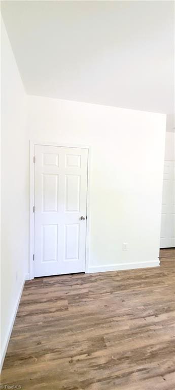 unfurnished room featuring wood finished floors and baseboards