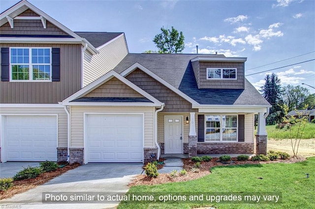 craftsman-style home with concrete driveway and a front lawn