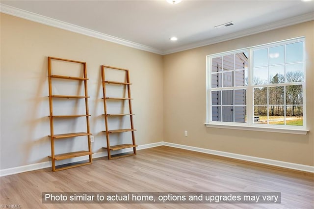 unfurnished room with baseboards, visible vents, ornamental molding, and wood finished floors