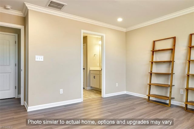 unfurnished bedroom featuring visible vents, ornamental molding, and wood finished floors