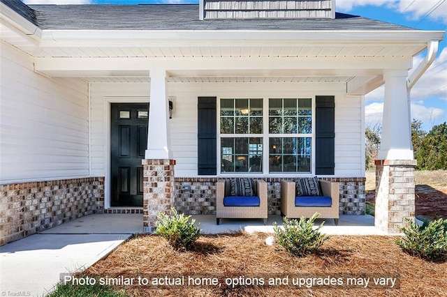 property entrance with covered porch, stone siding, and roof with shingles