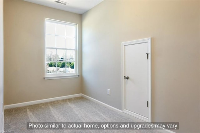 carpeted empty room with visible vents and baseboards