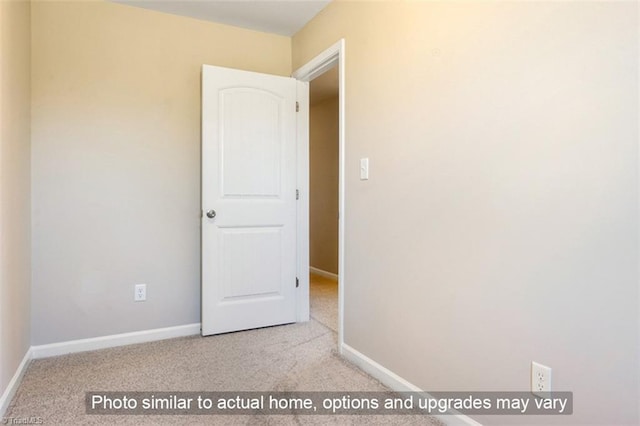 carpeted empty room featuring baseboards