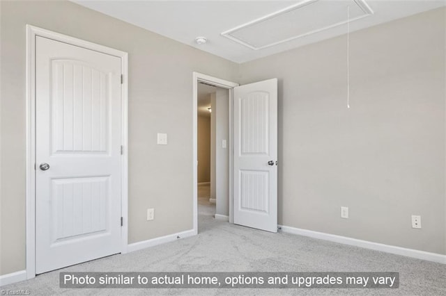 unfurnished bedroom featuring baseboards, carpet, and attic access
