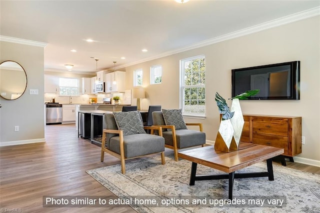 living area with crown molding, baseboards, recessed lighting, and light wood finished floors