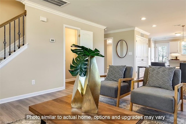 sitting room with crown molding, baseboards, light wood-type flooring, visible vents, and stairway