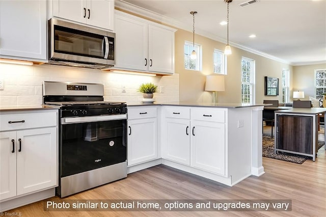 kitchen with ornamental molding, a peninsula, light wood-type flooring, white cabinetry, and stainless steel appliances