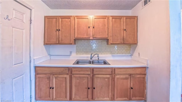 2914 Phillips Ave, Greensboro, NC 27405 - kitchen with light countertops, brown cabinets, tasteful backsplash, and a textured ceiling