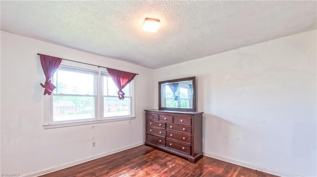 2914 Phillips Ave, Greensboro, NC 27405 - unfurnished bedroom featuring a textured ceiling and dark wood-style flooring