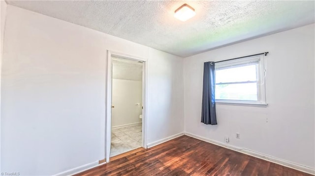 2914 Phillips Ave, Greensboro, NC 27405 - unfurnished room featuring dark wood-style flooring and a textured ceiling