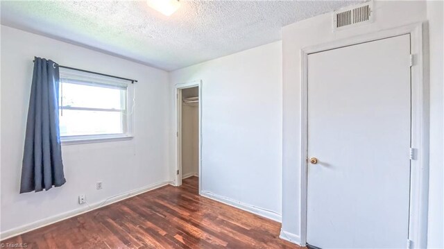 2914 Phillips Ave, Greensboro, NC 27405 - unfurnished bedroom with dark wood-type flooring and a textured ceiling