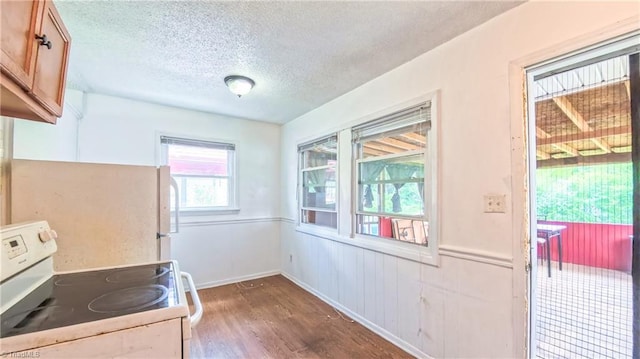 2914 Phillips Ave, Greensboro, NC 27405 - kitchen with white appliances, a textured ceiling, wood finished floors, brown cabinetry, and a wainscoted wall