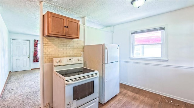 2914 Phillips Ave, Greensboro, NC 27405 - kitchen featuring white appliances, brown cabinets, tasteful backsplash, light wood-style flooring, and a textured ceiling