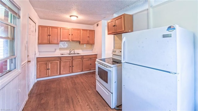 2914 Phillips Ave, Greensboro, NC 27405 - kitchen featuring white appliances, dark wood finished floors, backsplash, light countertops, and a textured ceiling