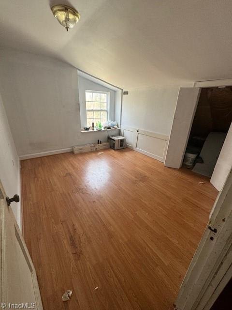 unfurnished bedroom featuring lofted ceiling and wood finished floors