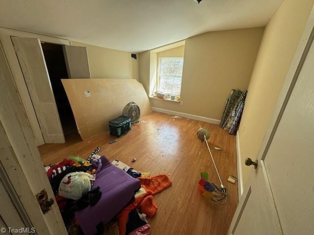 bedroom with lofted ceiling, baseboards, and wood finished floors