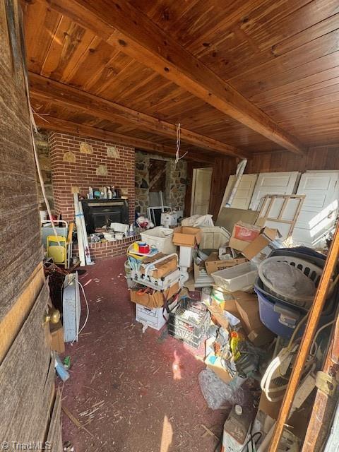 miscellaneous room with wood ceiling, brick wall, and beam ceiling