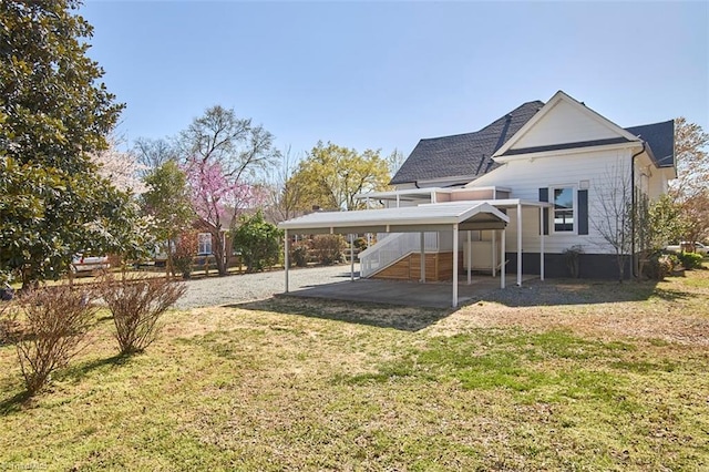 523 N Main St, Graham, NC 27253 - back of property with stairs, a patio, a detached carport, a shingled roof, and a lawn