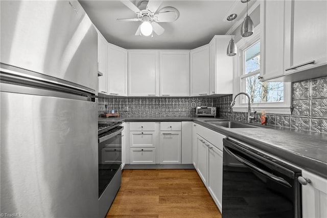 kitchen with stainless steel appliances, tasteful backsplash, dark countertops, and a sink