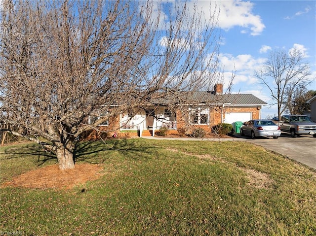 single story home with brick siding, a chimney, concrete driveway, a garage, and a front lawn