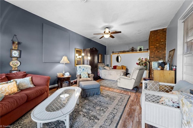 living room featuring a textured ceiling, wood finished floors, and a ceiling fan