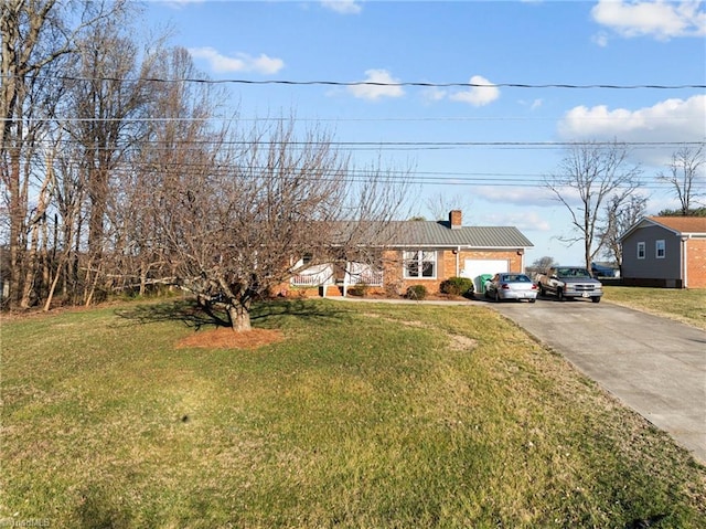 view of front of property featuring driveway, a chimney, and a front yard