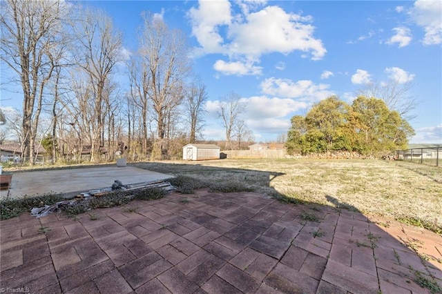 view of patio featuring an outdoor structure, a storage shed, and fence