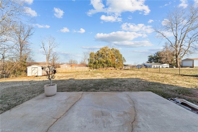 view of yard with an outbuilding, a shed, a patio area, and fence