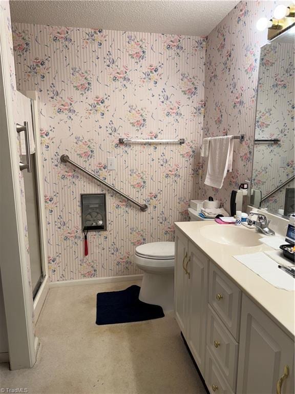 bathroom featuring vanity, a shower with shower door, toilet, and a textured ceiling