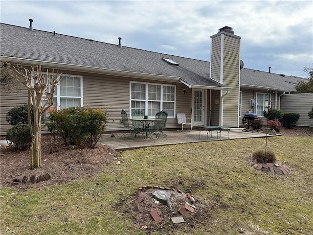 back of house featuring a patio area and a lawn