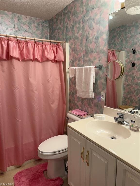 bathroom with a shower with curtain, vanity, a textured ceiling, and toilet