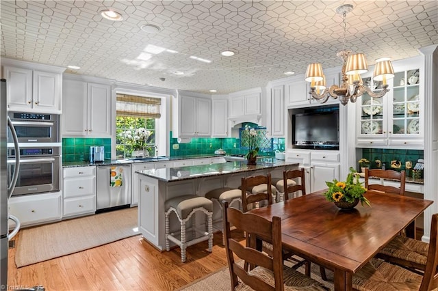 kitchen with dishwasher, tasteful backsplash, light wood-type flooring, a chandelier, and recessed lighting