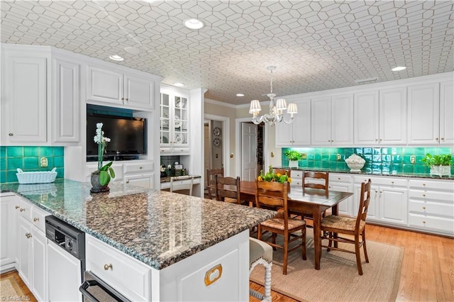 kitchen featuring white cabinets, a peninsula, tasteful backsplash, crown molding, and recessed lighting