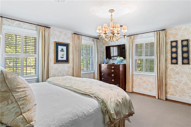 carpeted bedroom with wallpapered walls, a chandelier, and baseboards