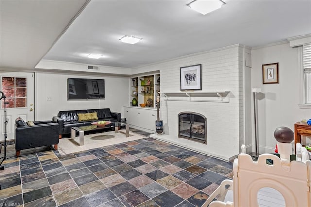 living room with dark stone finish floors and a fireplace