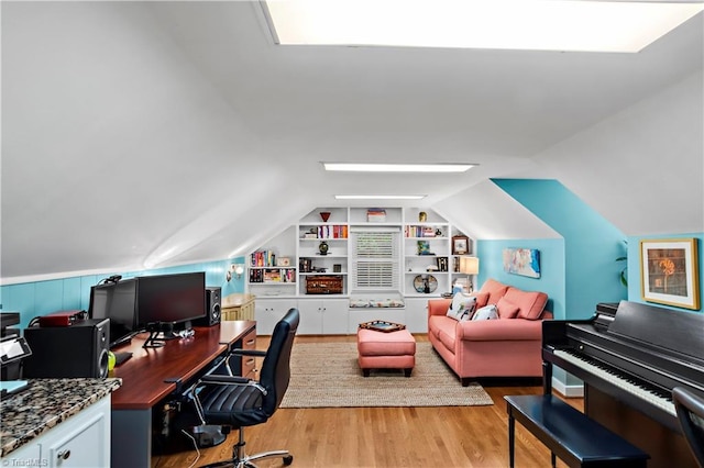office space featuring built in features, light wood-style floors, and lofted ceiling