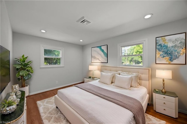 bedroom featuring multiple windows, visible vents, and wood finished floors