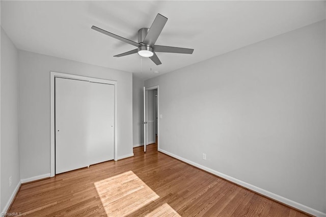 unfurnished bedroom with baseboards, a closet, and wood finished floors